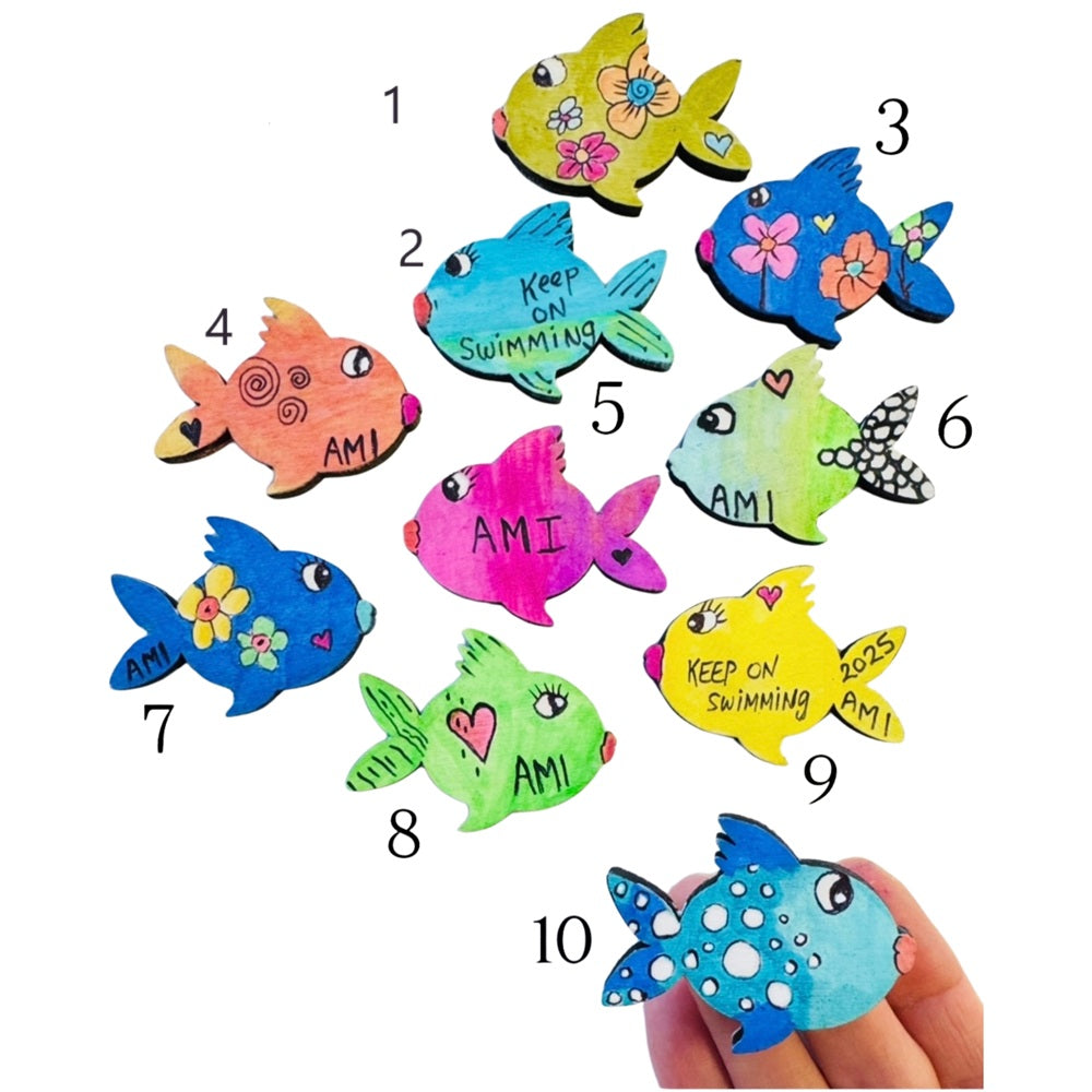variety of handmade wooden fish magnets in different colors