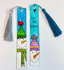 2 painted bookmarks with a snowman on each one. One saying 'Tis the Season' with a teal blue tassel