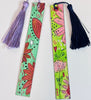 two painted bookmarks in colorful abstract floral designs. One with a purple tassel and another with a navy blue tassel