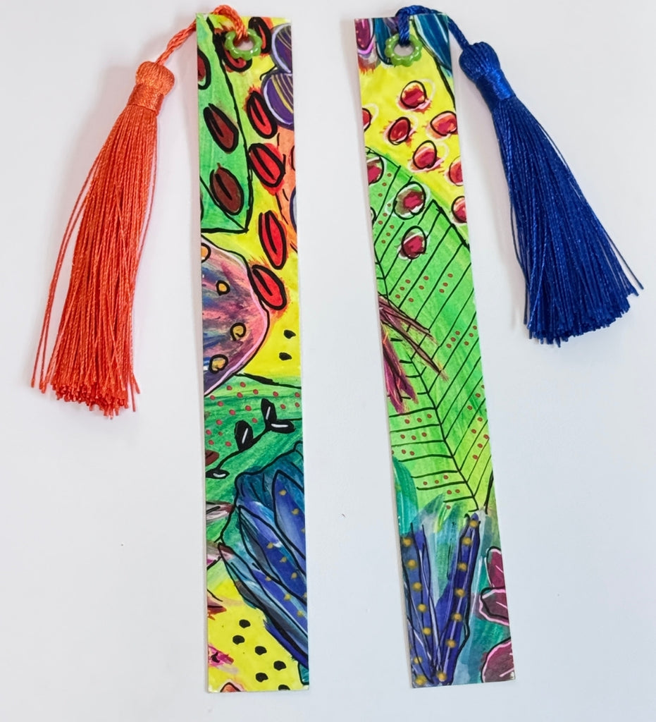 two bookmarks with colorful abstract art and tassels at the top