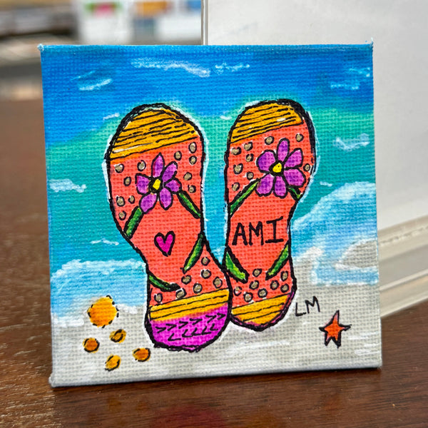 floral flip flops in orange and yellow on a beach setting