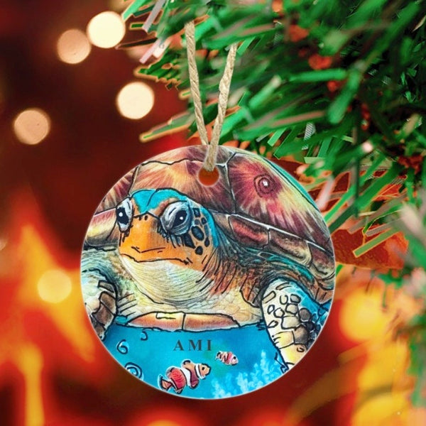 Sea turtle ornament hanging on a Christmas tree with blurred lights in the background. Letters AMI (Anna Maria Island)