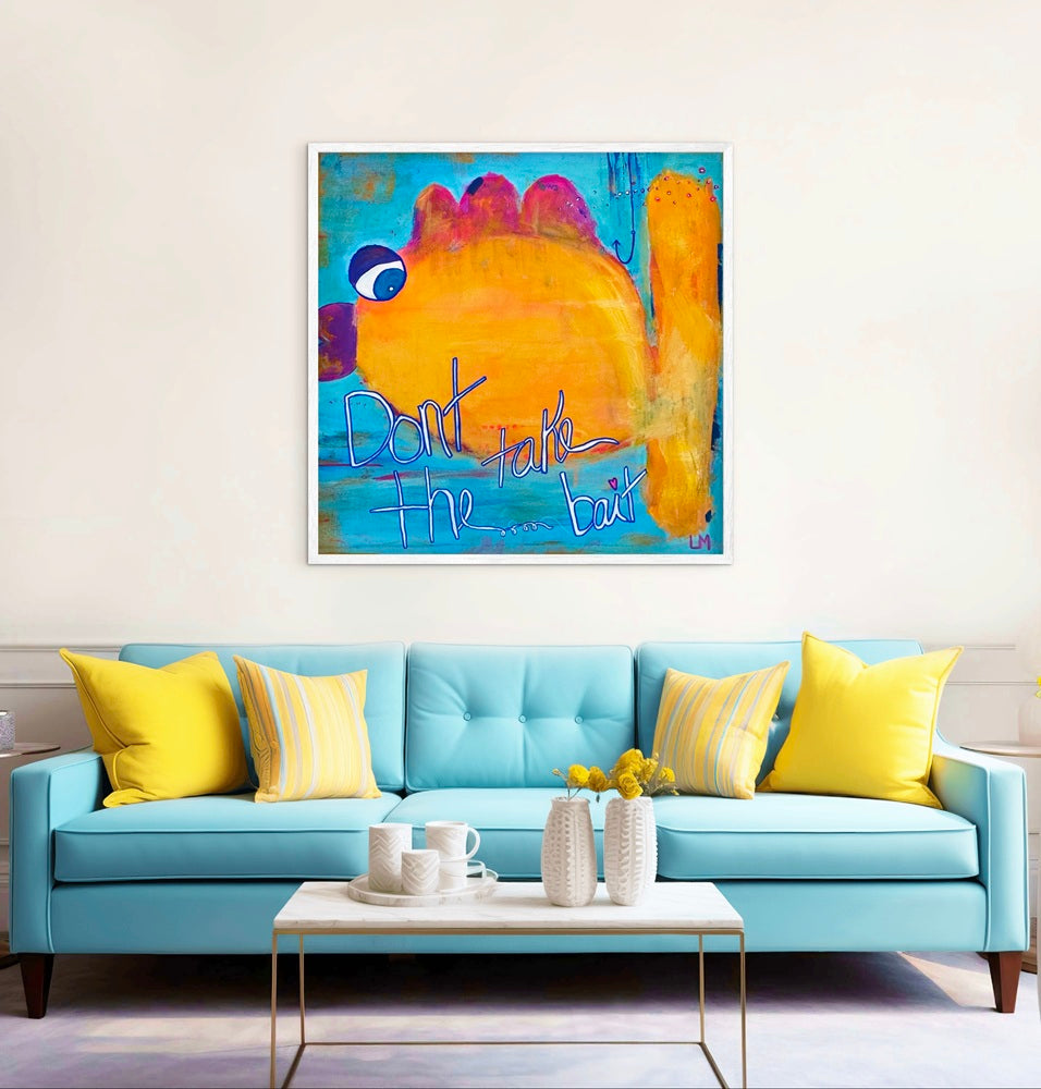 A colorful framed abstract fish painting hangs on a white wall above a bright turquoise sofa with yellow pillows in a styled living room.