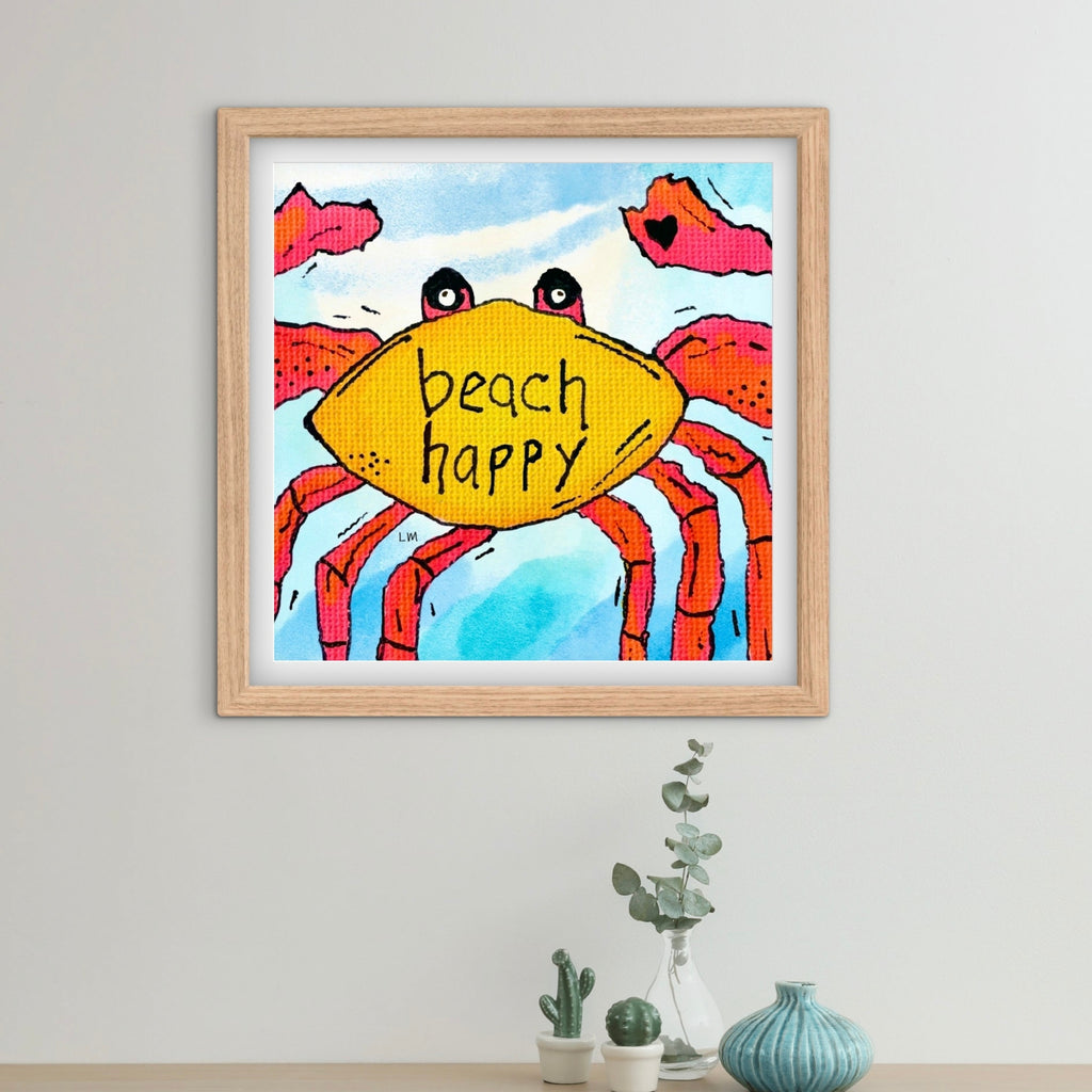 Framed artwork of a crab and text saying 'beach happy' on a wall.
