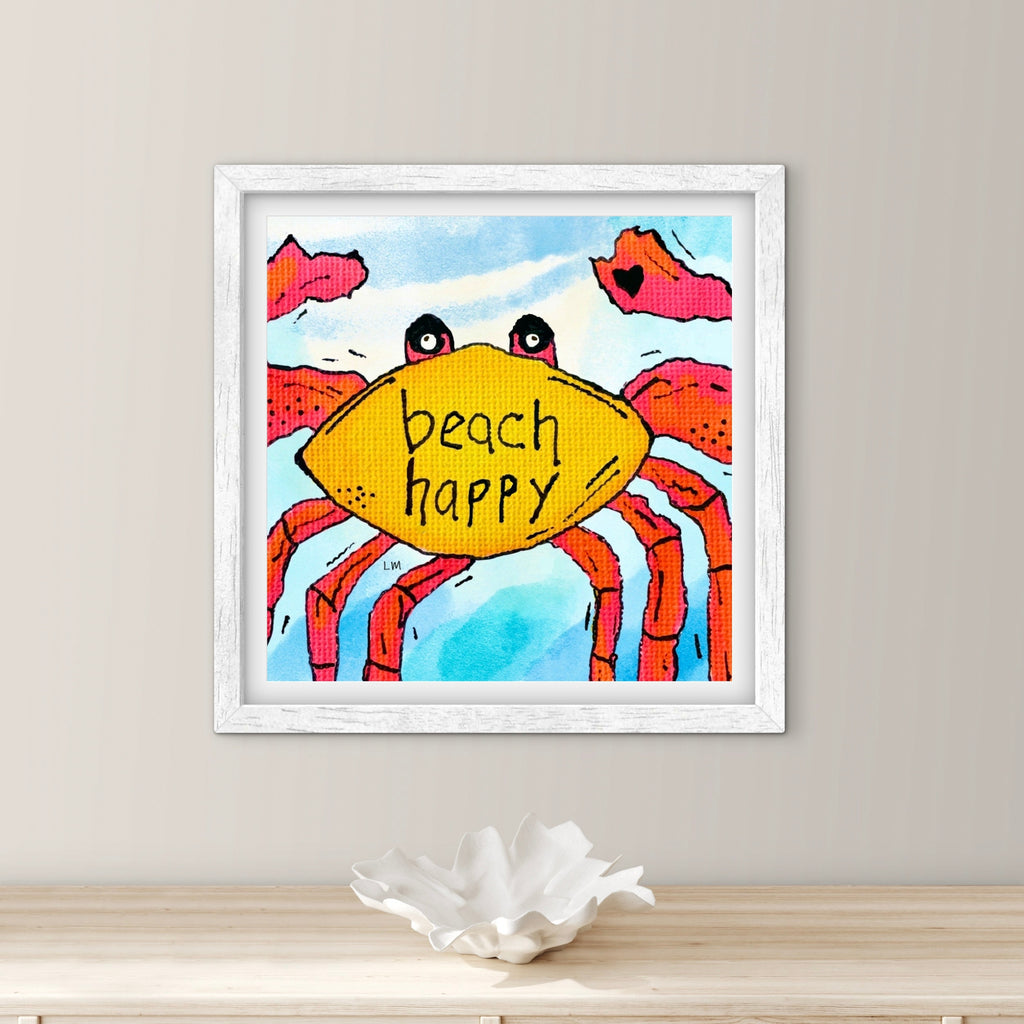 Framed artwork of a crab with 'beach happy' on a shelf against a beige wall