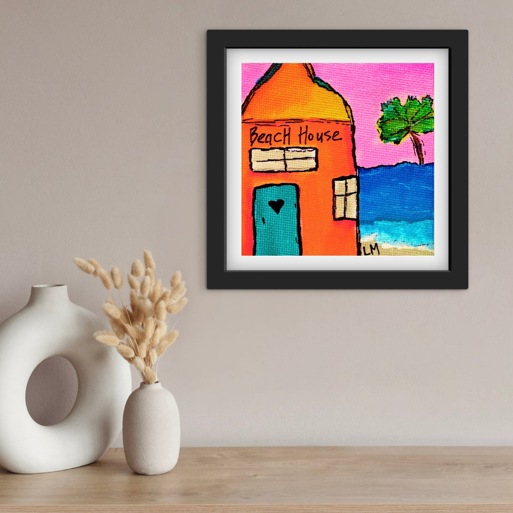 Framed artwork of a beach house with a palm tree on a wall above two vases.