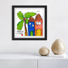 Framed artwork with colorful houses and palm tree on a white wall.