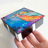 Birds of Color art block held flat at an angle, showing the colorful bird artwork and black-and-white striped sides
