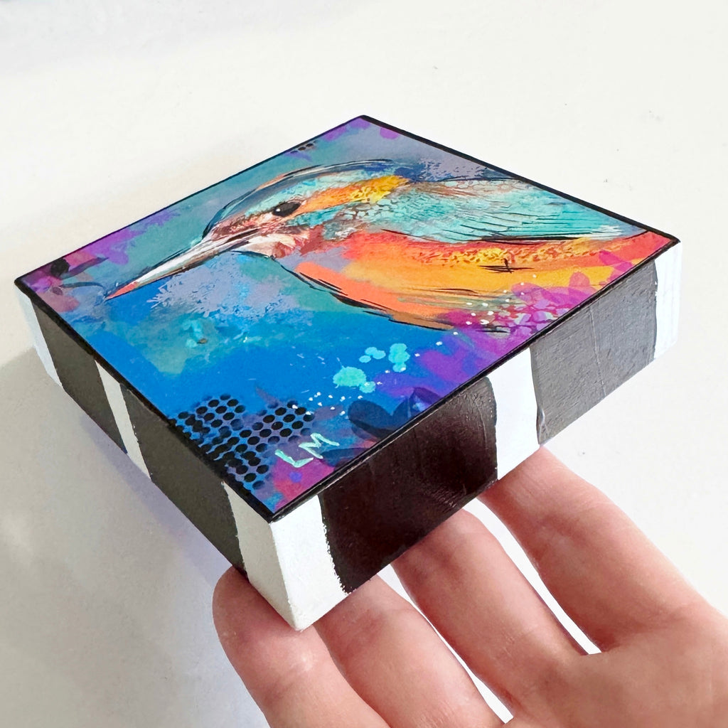 Birds of Color art block held flat at an angle, showing the colorful bird artwork and black-and-white striped sides