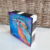 Angled view of Birds of Color art block, showing the colorful bird artwork and hand-painted black-and-white striped top and side.
