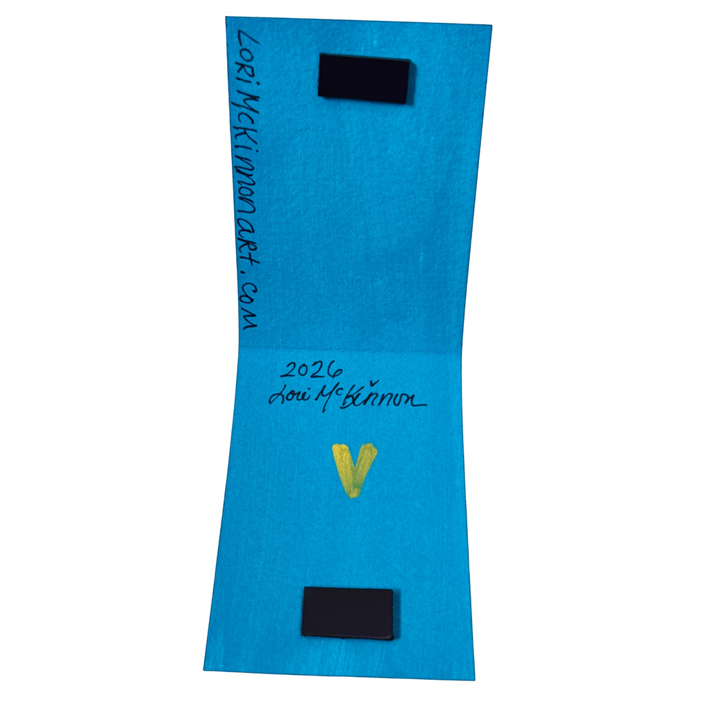 inside of magnetic bookmark painted blue showing artist signature 'Lori McKinnon' and a yellow heart