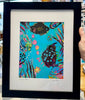 Framed colorful artwork of fish on a blue background