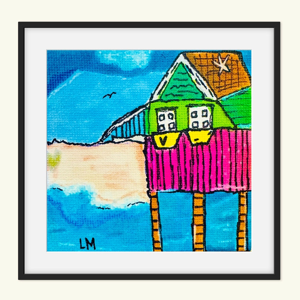 Colorful art print of a house with a black frame