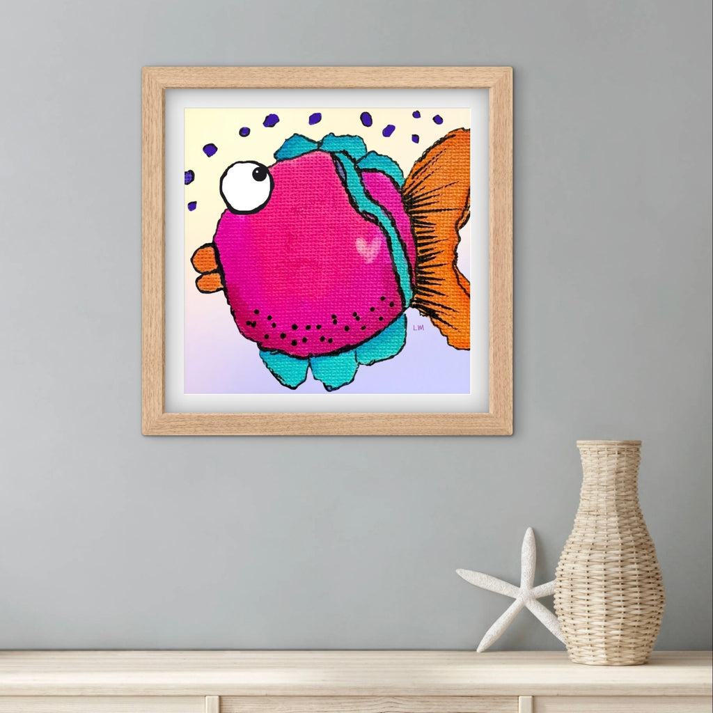 Framed colorful fish artwork on a gray wall with a vase and starfish below.