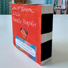 back of a painted wood block showing black and white sides, artist signature and a colorful heart and the year '2026'