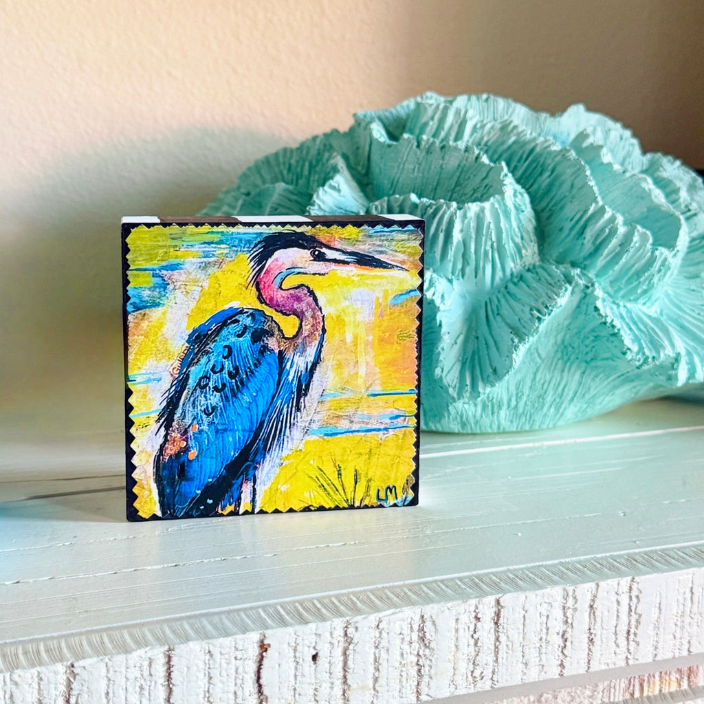 a free standing painting on a white table next to a decorative blue sea coral
