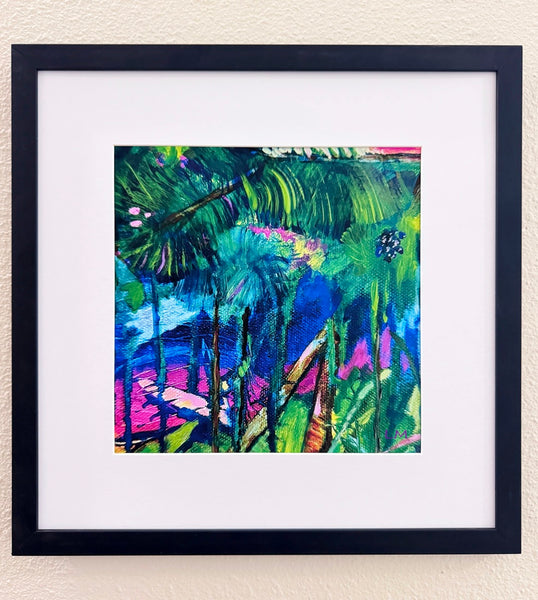 Vibrant botanical art print in a matted black frame on a light beige wall