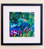 Vibrant botanical art print in a matted black frame on a light beige wall