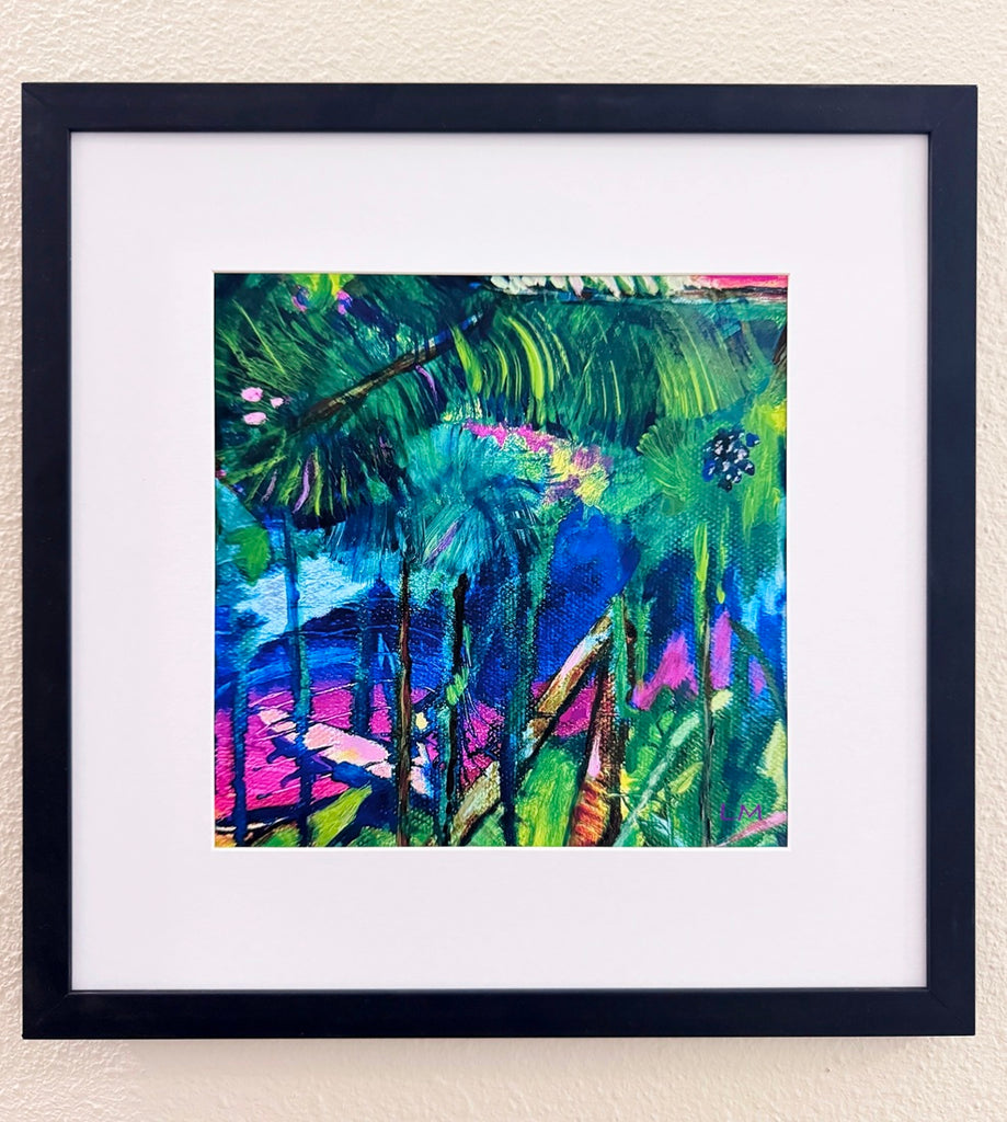 Vibrant botanical art print in a matted black frame on a light beige wall