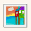 whimsical beach art in black frame on a white wall