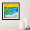 Framed artwork of a beach scene with a palm tree on a white wall.