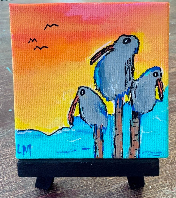 Small painting of three birds on a stand with a sunset background
