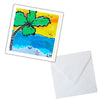 Card with a tropical design featuring a palm tree, beach, and ocean, accompanied by a white envelope.