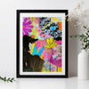 Framed abstract artwork with colorful flowers on a white surface.