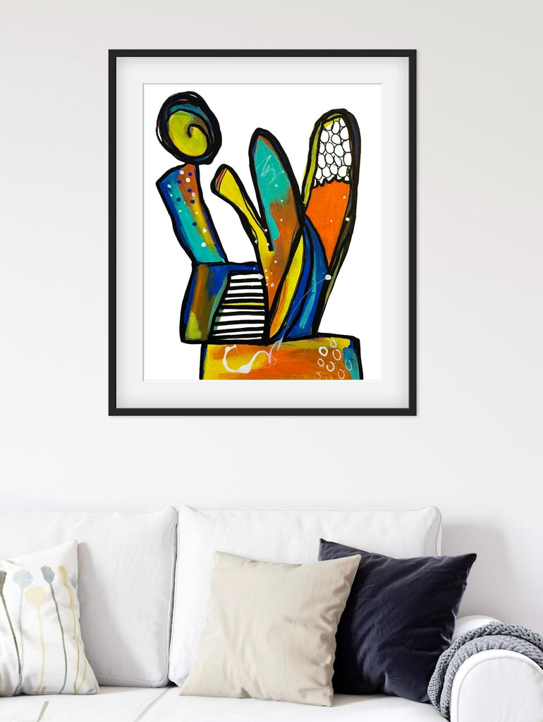 Framed abstract artwork on a wall above a sofa with cushions.