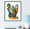 Framed abstract artwork with colorful design on a wall above a table with decorative items.