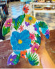 Colorful turtle-shaped art piece with floral patterns held by a hand.