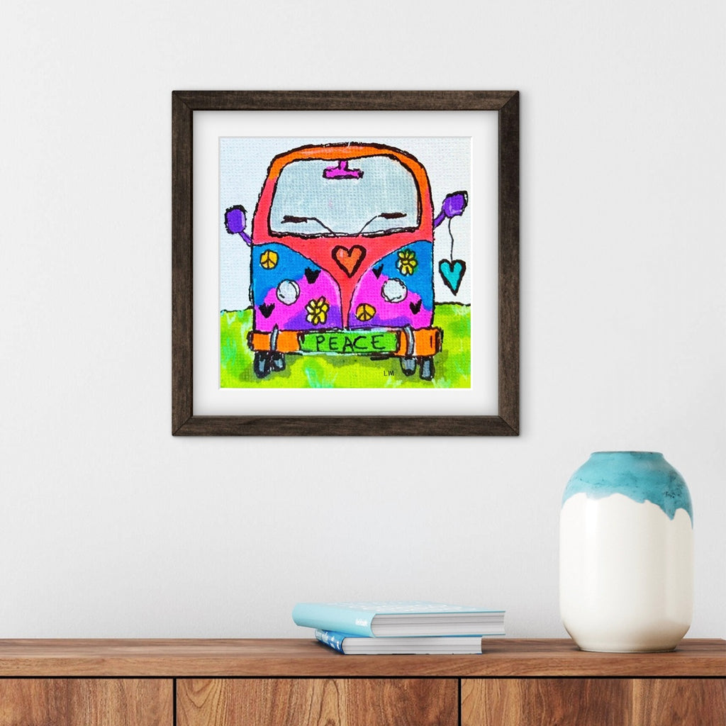Framed colorful artwork of a van with peace sign on a white wall above a wooden shelf.