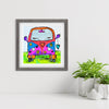 Framed artwork of a colorful VW van with 'peace' text on a white wall.