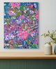 Colorful abstract painting on a wall above a wooden shelf with decorative items.