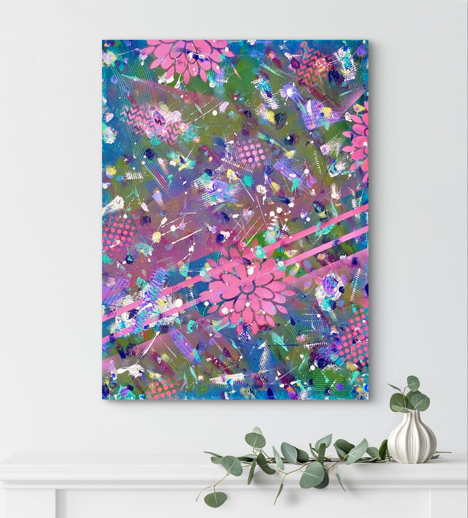 Abstract artwork with pink flowers on a white wall above a white shelf with greenery and a vase.