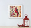 Framed artwork of a red cardinal bird on a branch with berries, next to a red lantern and decorative branches on a light blue wall.