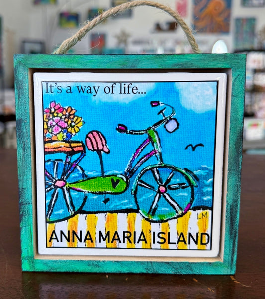Original art with a bicycle and text 'It's a way of life... Anna Maria Island' in a hand painted wood frame.