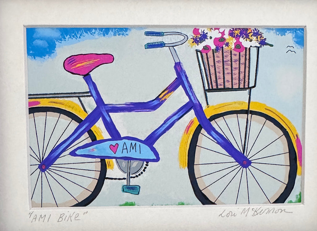 A colorful art print depicting a bicycle with a basket of flowers, signed by artist Lori McKinnon, presented on a white mat board.