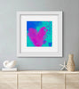Framed abstract art with pink and blue hearts on a gray wall above a wooden cabinet.