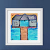 Framed artwork of pier building with 'AM' on a blue background