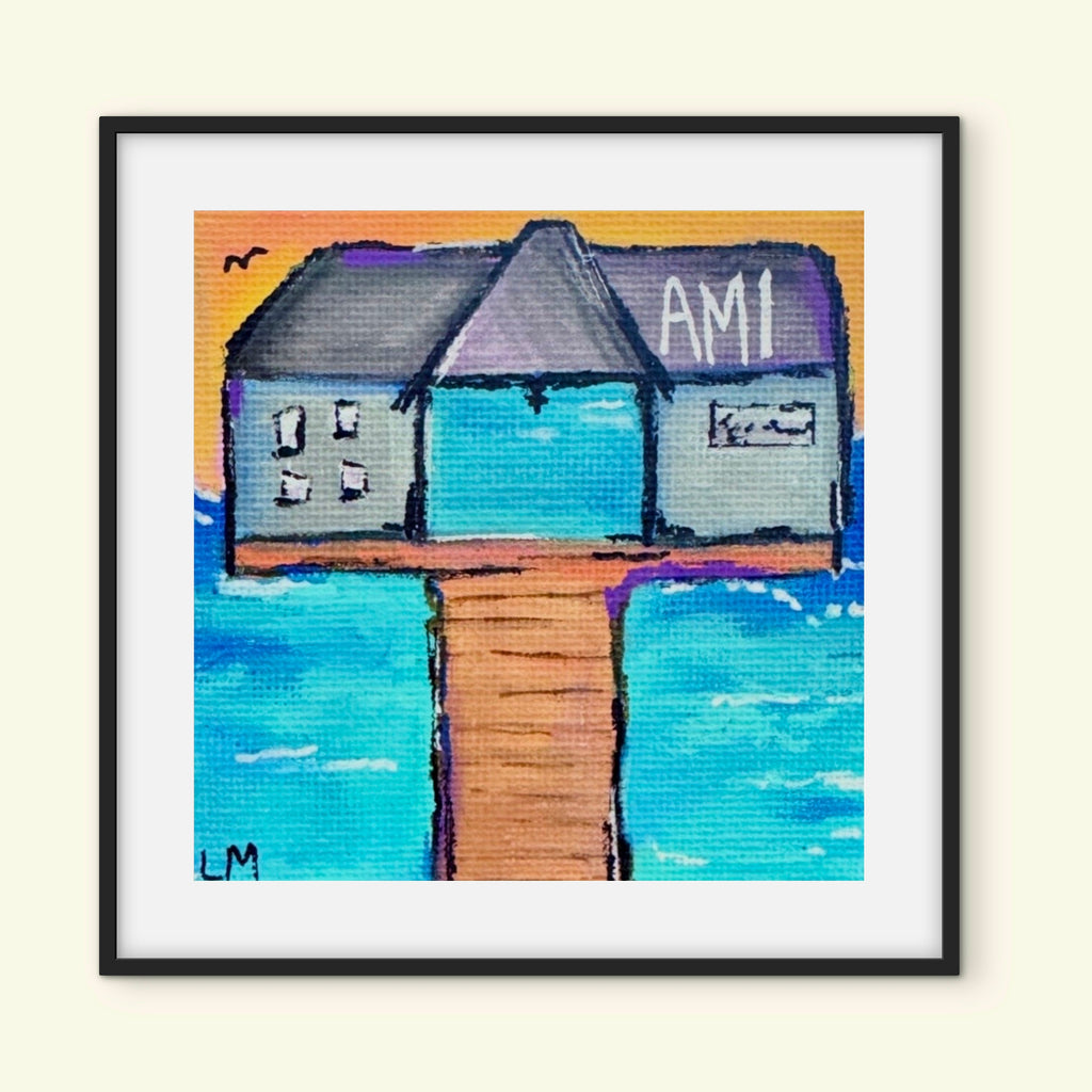 Framed artwork of pier with "AMI" text on building with water scene as background