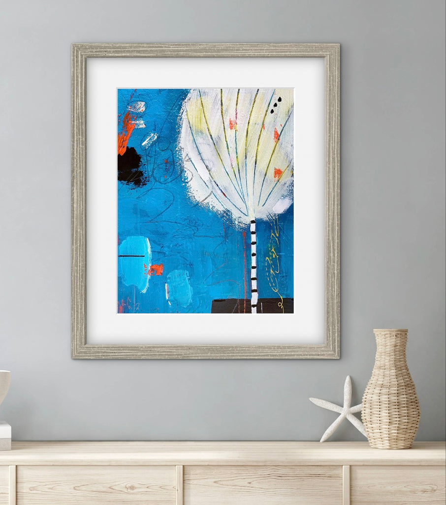 Framed abstract art piece on a wall with decorative items below.