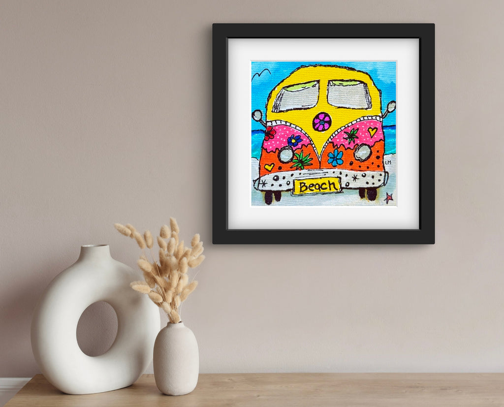 Framed artwork of a colorful van with 'Beach' text on a wall above two decorative vases.