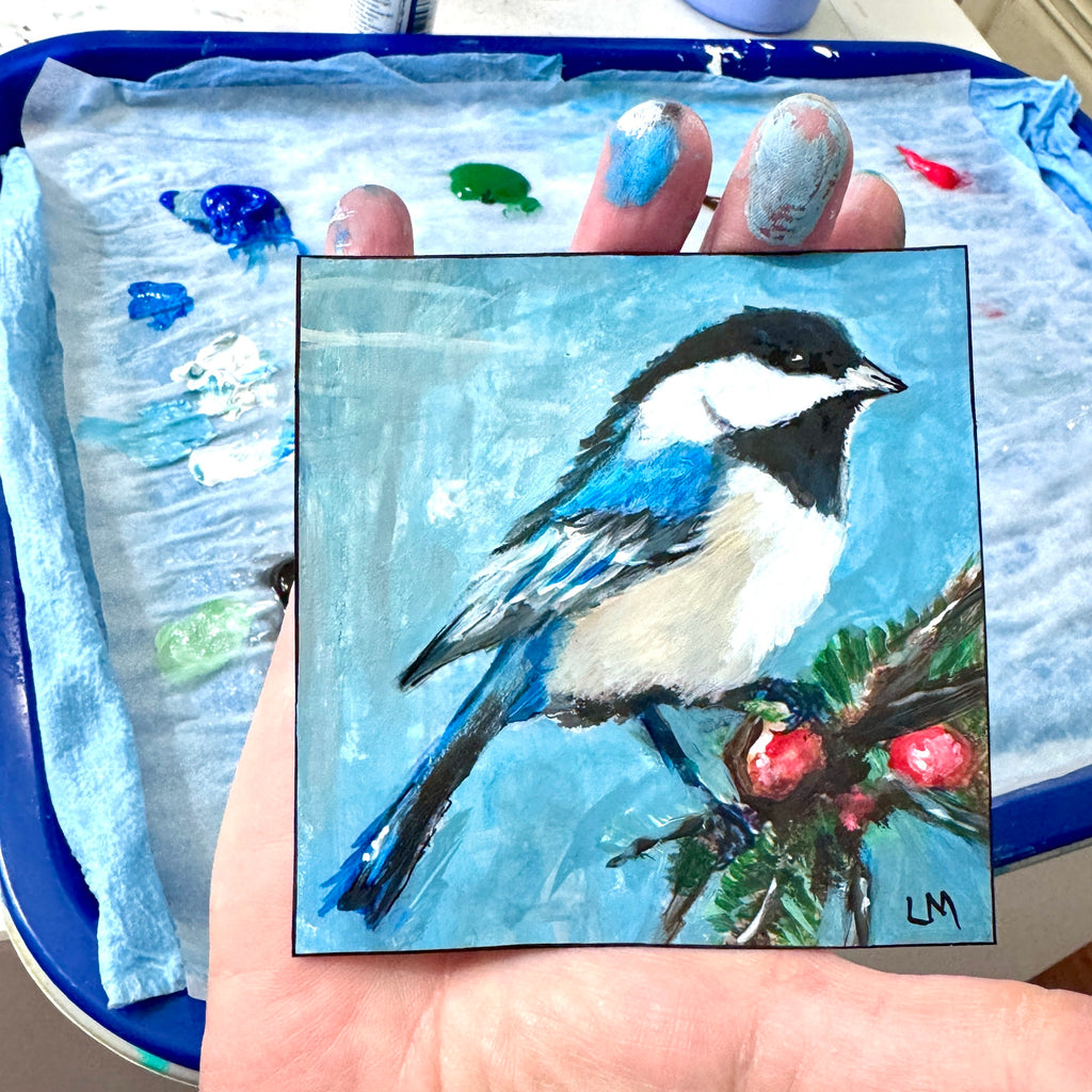 Bird and Berries 4x4 acrylic painting by Lori McKinnon, held in a paint-covered hand above a palette to show its size