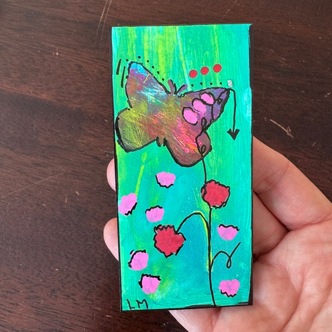 painted bookmark with a butterfly held by a hand