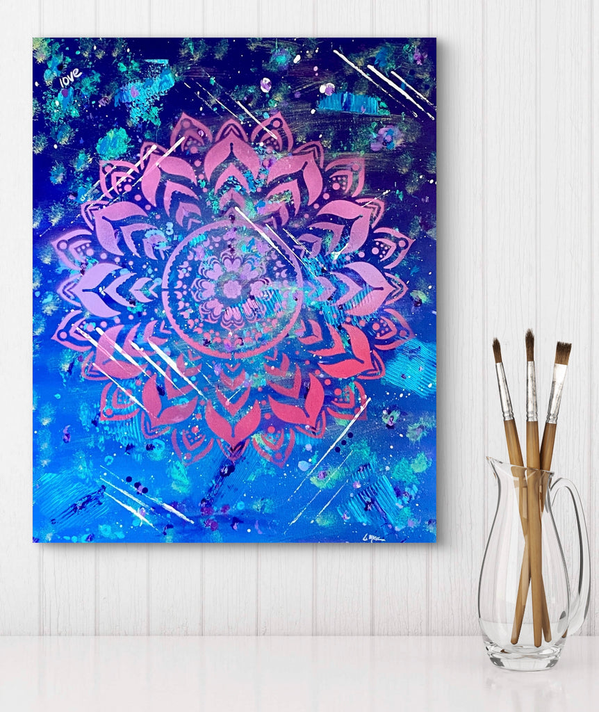 Colorful painting on a white wall with paintbrushes in a glass.