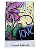 A rectangular magnetic bookmark with a colorful artistic design featuring a pink flower, green leaves, black swirls, and the word 'love' in blue, above a white strip labeled 'Magnetic Bookmark'.