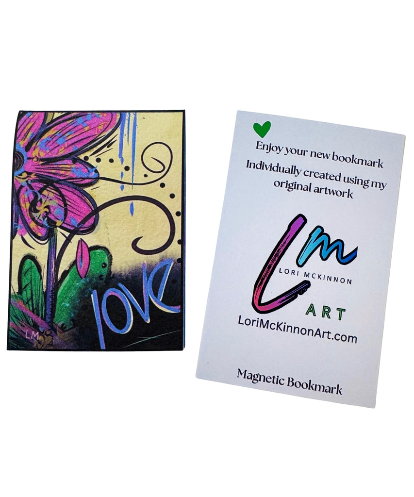 A custom magnetic bookmark featuring colorful abstract floral artwork shown next to a paper with printed text and the artist's name Lori McKinnon.
