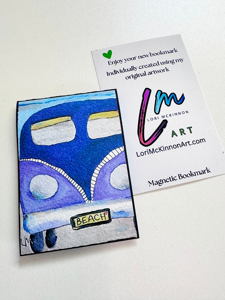 A custom illustrated magnetic bookmark featuring a blue and purple VW bus with a 'BEACH' license plate, shown next to its white backing card printed with the artist's name Lori McKinnon Art.