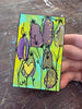 small painting being held by a hand on a wood surface